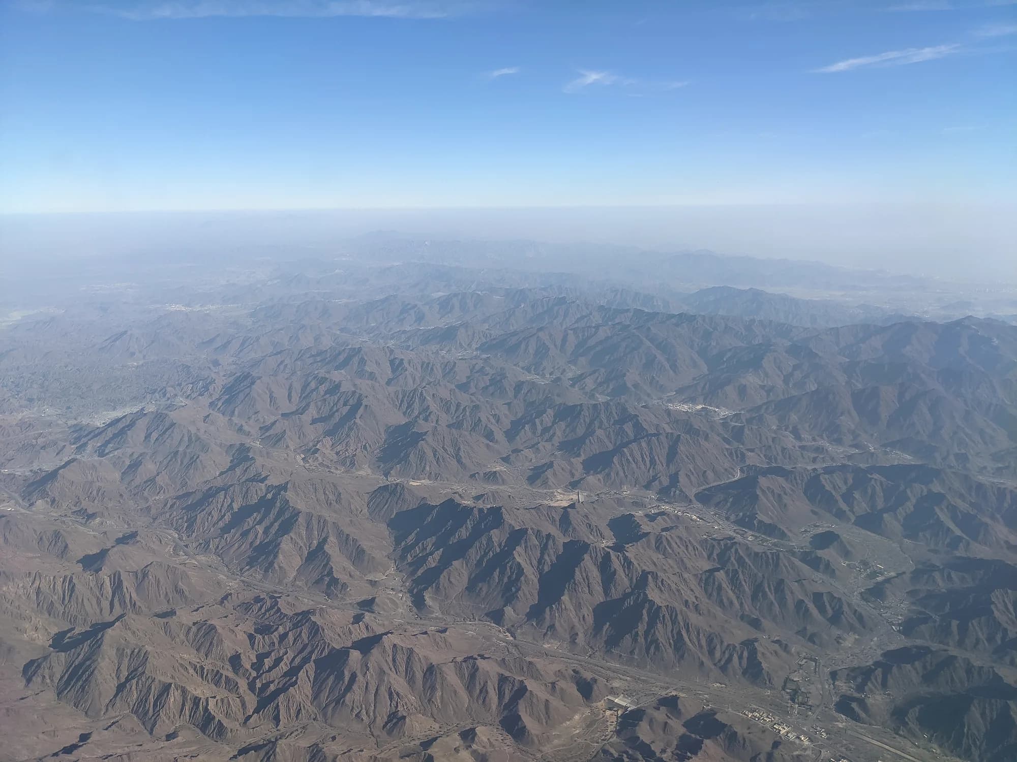 Aerial view of rugged mountain ranges from a plane window